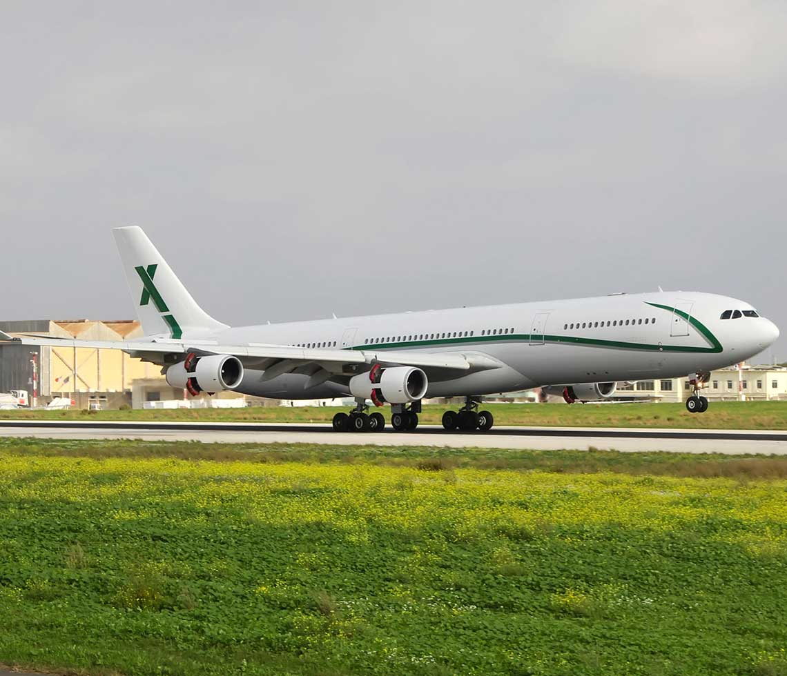 Airbus A340-300 private aircraft charter plane taking off from runway with grass