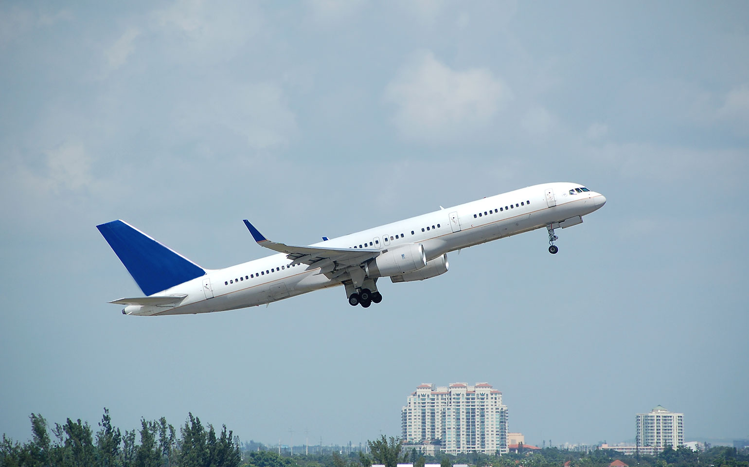 Boeing B757-200 private aircraft charter flight takeoff with city view