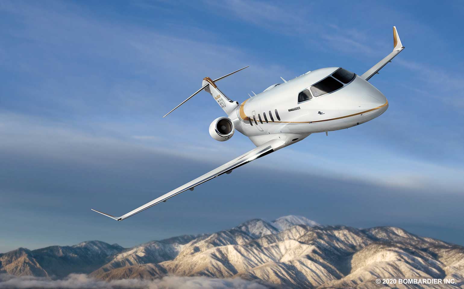 Bombardier Challenger 350 private jet charter in flight over mountains