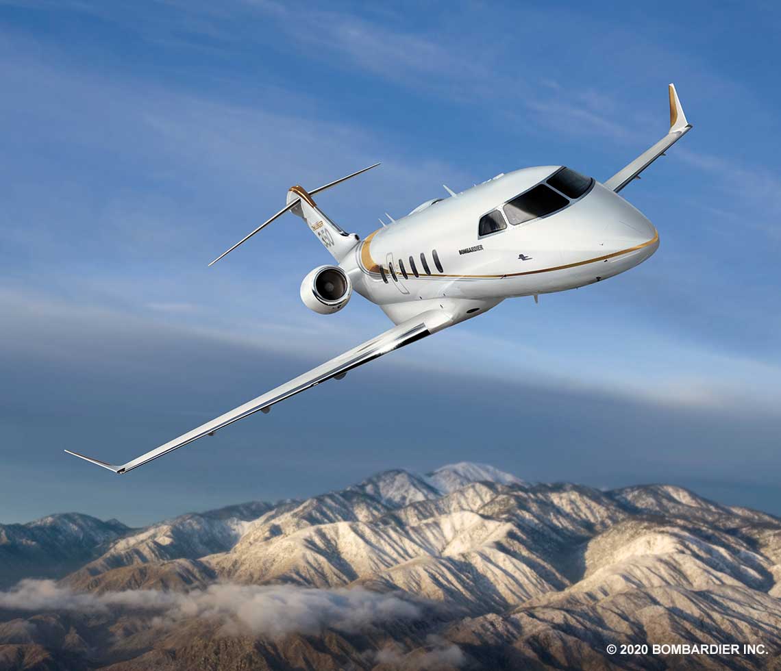 Bombardier Challenger 350 private jet charter in flight over mountains
