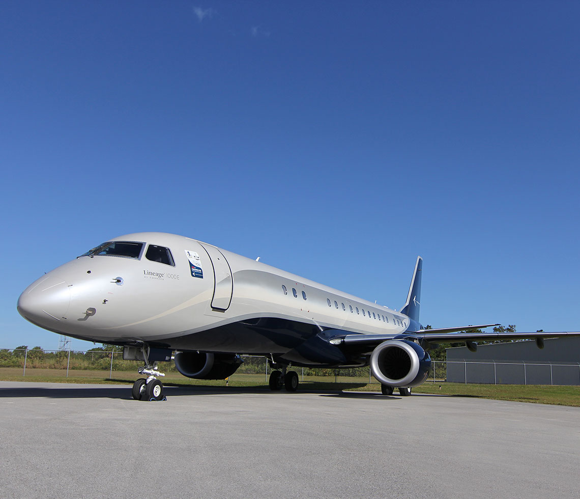 Embraer Lineage 1000 private jet charter parked by airport